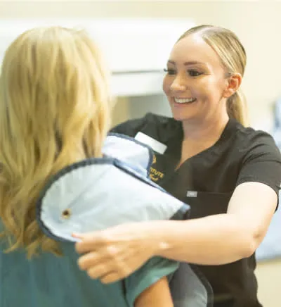 Inland Institute team member placing a protective X-ray apron on a patient