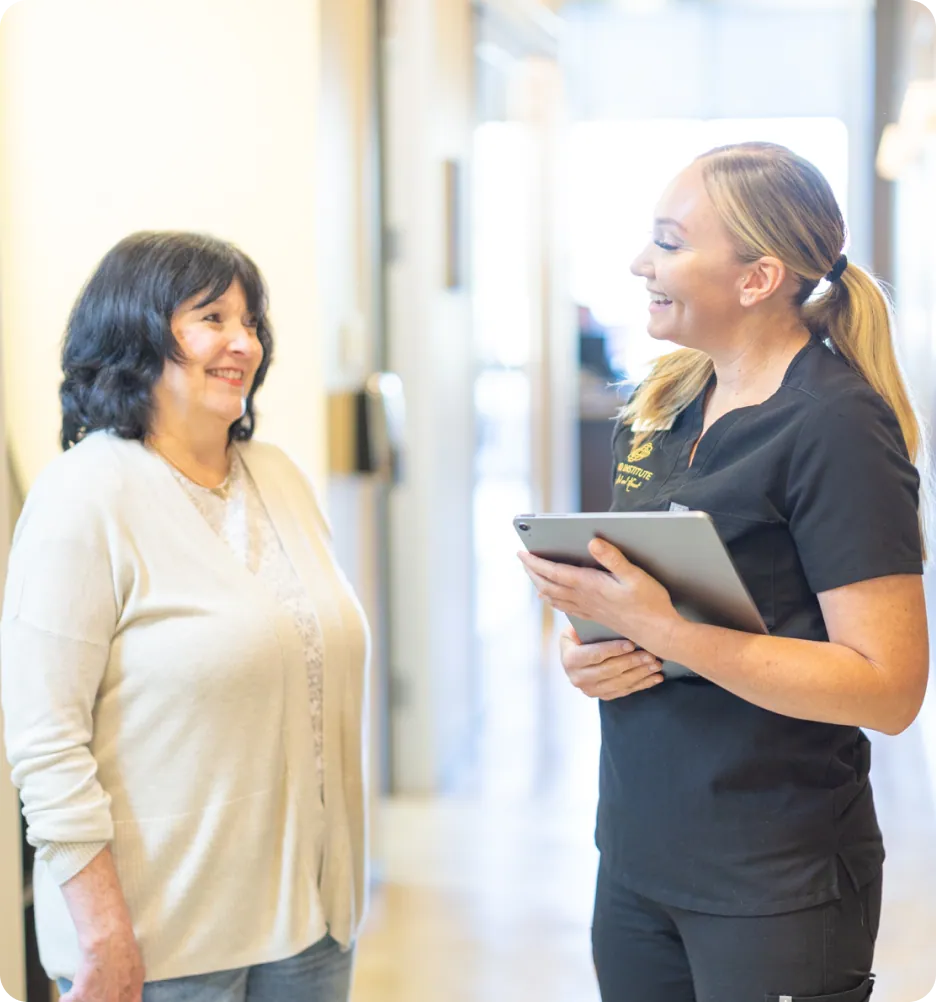 Inland Institute team member with a tablet greeting a patient